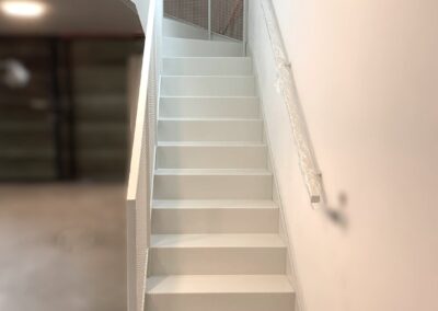 Schody dywanowe z giętej blachy, balustrada z siatki, całość malowana proszkowo