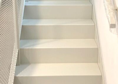 Schody dywanowe z giętej blachy, balustrada z siatki, całość malowana proszkowo