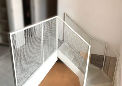 Schody dywanowe z giętej blachy, balustrada z siatki, całość malowana proszkowo